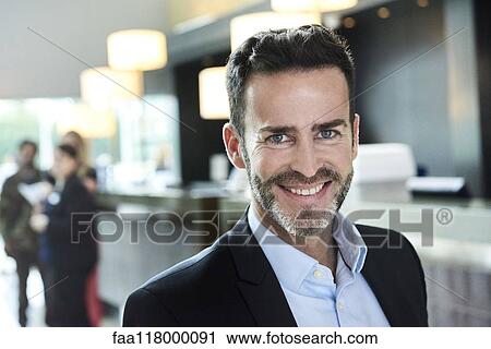 Portrait of businessman standing in hotel View Large Photo Image Stock Image - Portrait of businessman standing in hotel. Fotosearch