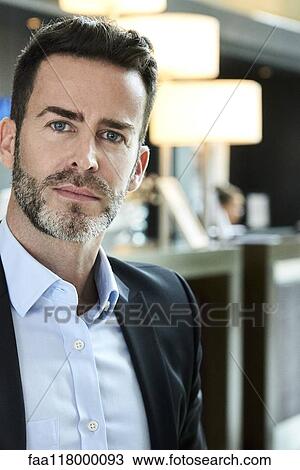 Portrait of businessman standing in hotel View Large Photo Image Stock Image - Portrait of businessman standing in hotel. Fotosearch