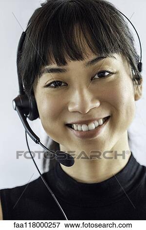 Stock Photo - Portrait of businesswoman wearing headset. Fotosearch