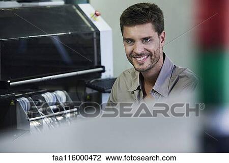 Stock Image - Portrait of engineer sitting in office. Fotosearch