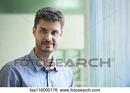 Stock Photograph - Portrait of engineer standing in office. Fotosearch