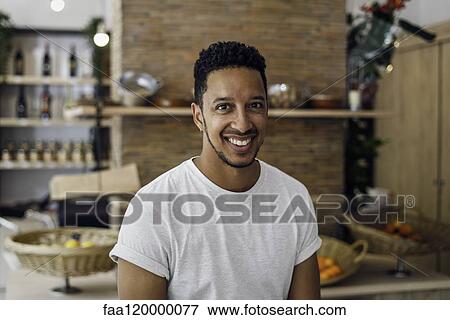 Stock Photo - Portrait of man sitting in shop. Fotosearch