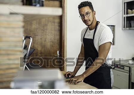 Portrait of man standing in commercial kitchen View Large Photo Image Stock Image - Portrait of man standing in commercial kitchen. Fotosearch