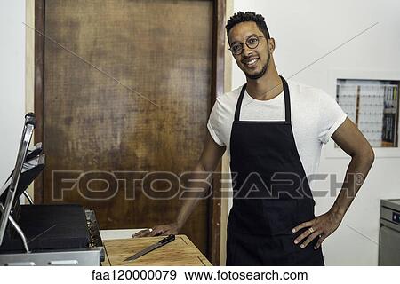 Portrait of man standing in commercial kitchen View Large Photo Image Stock Photo - Portrait of man standing in commercial kitchen. Fotosearch