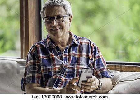 Stock Photo - Portrait of mature man using smartphone. Fotosearch
