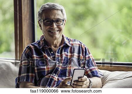 Portrait of mature man using smartphone View Large Photo Image Stock Photograph - Portrait of mature man using smartphone. Fotosearch