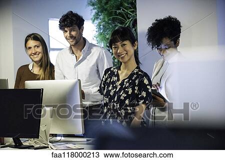 Portrait of smiling business people standing in office View Large Photo Image Stock Image - Portrait of smiling business people standing in office. Fotosearch