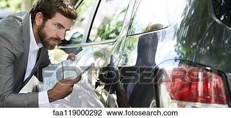 Salesman examining car View Large Photo Image Stock Image - Salesman examining car. Fotosearch