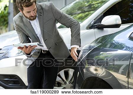 Salesman examining car View Large Photo Image Stock Photo - Salesman examining car. Fotosearch