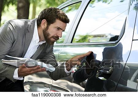 Salesman examining car View Large Photo Image Stock Photo - Salesman examining car. Fotosearch