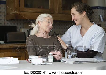 Stock Image - Senior patient talking with nurse. Fotosearch