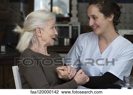 Stock Image - Senior patient talking with nurse. Fotosearch