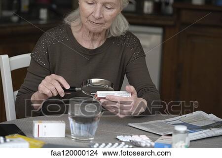 Senior woman reading label of pill box View Large Photo Image Picture - Senior woman reading label of pill box. Fotosearch