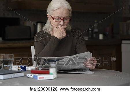 Senior woman reading newspaper View Large Photo Image Stock Photo - Senior woman reading newspaper. Fotosearch