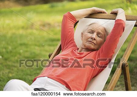 Senior woman relaxing on chair View Large Photo Image Picture - Senior woman relaxing on chair. Fotosearch