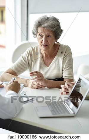 Senior woman sitting in the clinic View Large Photo Image Stock Photograph - Senior woman sitting in the clinic. Fotosearch