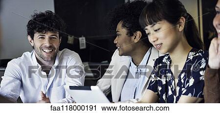 Smiling business people sitting in office View Large Photo Image Stock Image - Smiling business people sitting in office. Fotosearch