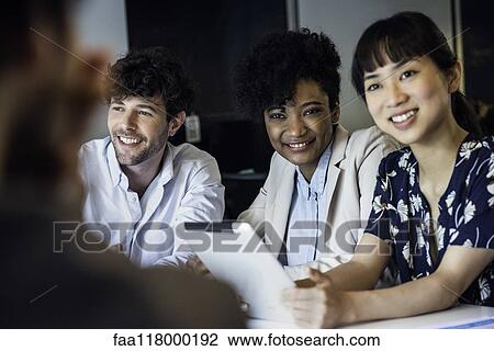 Smiling business people sitting in office View Large Photo Image Stock Image - Smiling business people sitting in office. Fotosearch