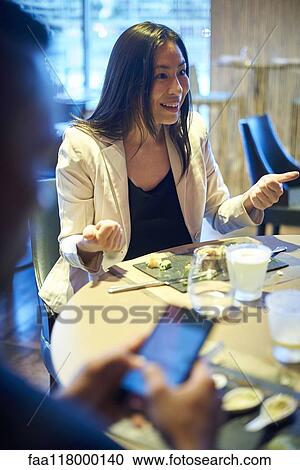 Smiling business woman sitting in bar View Large Photo Image Stock Image - Smiling business woman sitting in bar. Fotosearch