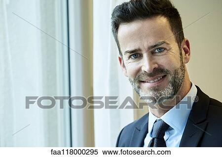 Smiling businessman standing in hotel View Large Photo Image Stock Photography - Smiling businessman standing in hotel. Fotosearch