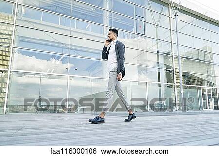 Smiling businessman talking on smartphone View Large Photo Image Stock Photograph - Smiling businessman talking on smartphone. Fotosearch
