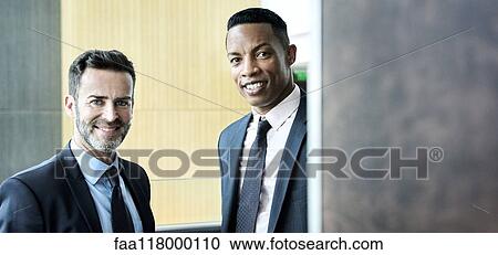 Smiling businessmen standing in hotel lobby View Large Photo Image Stock Image - Smiling businessmen standing in hotel lobby. Fotosearch