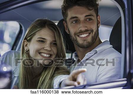 Smiling couple sitting in car View Large Photo Image Stock Photo - Smiling couple sitting in car. Fotosearch