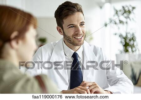 Smiling doctor talking with patient View Large Photo Image Stock Photograph - Smiling doctor talking with patient. Fotosearch