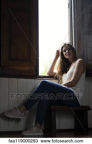 Smiling woman sitting near window View Large Photo Image Stock Image - Smiling woman sitting near window. Fotosearch