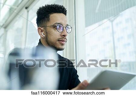 Thoughtful businessman holding digital tablet View Large Photo Image Stock Photo - Thoughtful businessman holding digital tablet. Fotosearch