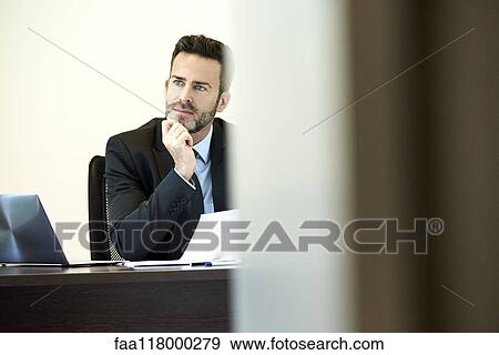 Thoughtful businessman sitting in office View Large Photo Image Stock Photo - Thoughtful businessman sitting in office. Fotosearch