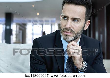 Stock Photo - Thoughtful businessman sitting on sofa. Fotosearch