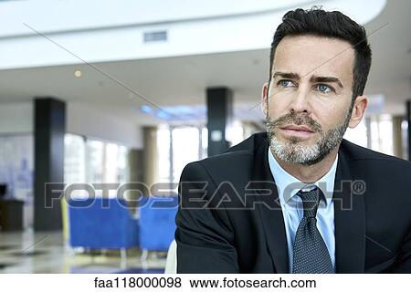 Thoughtful businessman sitting on sofa View Large Photo Image Stock Photo - Thoughtful businessman sitting on sofa. Fotosearch