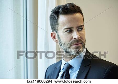 Thoughtful businessman standing in hotel View Large Photo Image Picture - Thoughtful businessman standing in hotel. Fotosearch