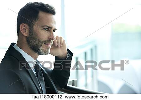 Thoughtful businessman standing in hotel lobby View Large Photo Image Stock Image - Thoughtful businessman standing in hotel lobby. Fotosearch