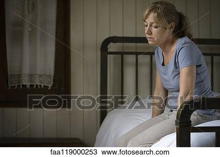 Thoughtful sad woman sitting on bed View Large Photo Image Stock Image - Thoughtful sad woman sitting on bed. Fotosearch