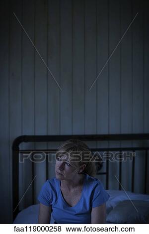 Thoughtful sad woman sitting on bed View Large Photo Image Stock Photo - Thoughtful sad woman sitting on bed. Fotosearch