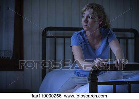 Thoughtful sad woman sitting on bed View Large Photo Image Stock Photograph - Thoughtful sad woman sitting on bed. Fotosearch