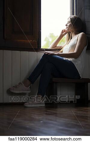 Thoughtful woman looking through window View Large Photo Image Picture - Thoughtful woman looking through window. Fotosearch