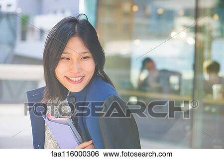 Woman holding laptop and file View Large Photo Image Stock Photograph - Woman holding laptop and file. Fotosearch