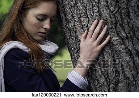 Woman leaning on tree trunk View Large Photo Image Stock Image - Woman leaning on tree trunk. Fotosearch