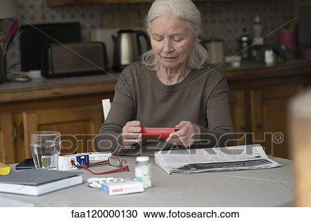 Woman looking at pill box View Large Photo Image Stock Image - Woman looking at pill box. Fotosearch