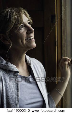 Woman looking through window View Large Photo Image Stock Image - Woman looking through window. Fotosearch