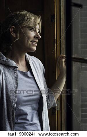Woman looking through window View Large Photo Image Stock Image - Woman looking through window. Fotosearch