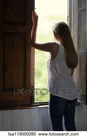 Woman looking through window View Large Photo Image Stock Image - Woman looking through window. Fotosearch