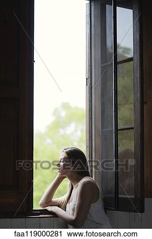 Woman looking through window View Large Photo Image Stock Image - Woman looking through window. Fotosearch