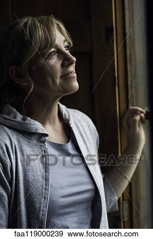 Woman looking through window View Large Photo Image Stock Photo - Woman looking through window. Fotosearch