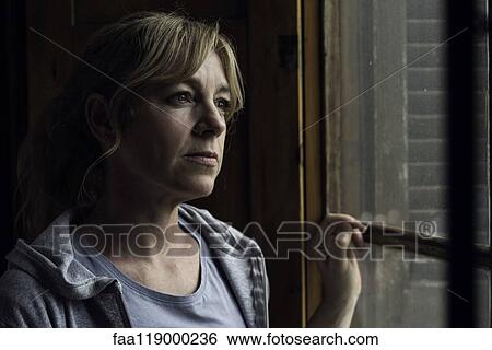 Woman looking through window View Large Photo Image Stock Photograph - Woman looking through window. Fotosearch