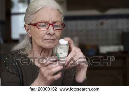 Woman reading label of pill bottle View Large Photo Image Stock Image - Woman reading label of pill bottle. Fotosearch