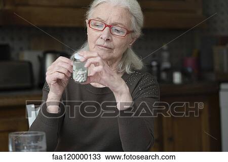 Woman reading label of pill bottle View Large Photo Image Stock Image - Woman reading label of pill bottle. Fotosearch